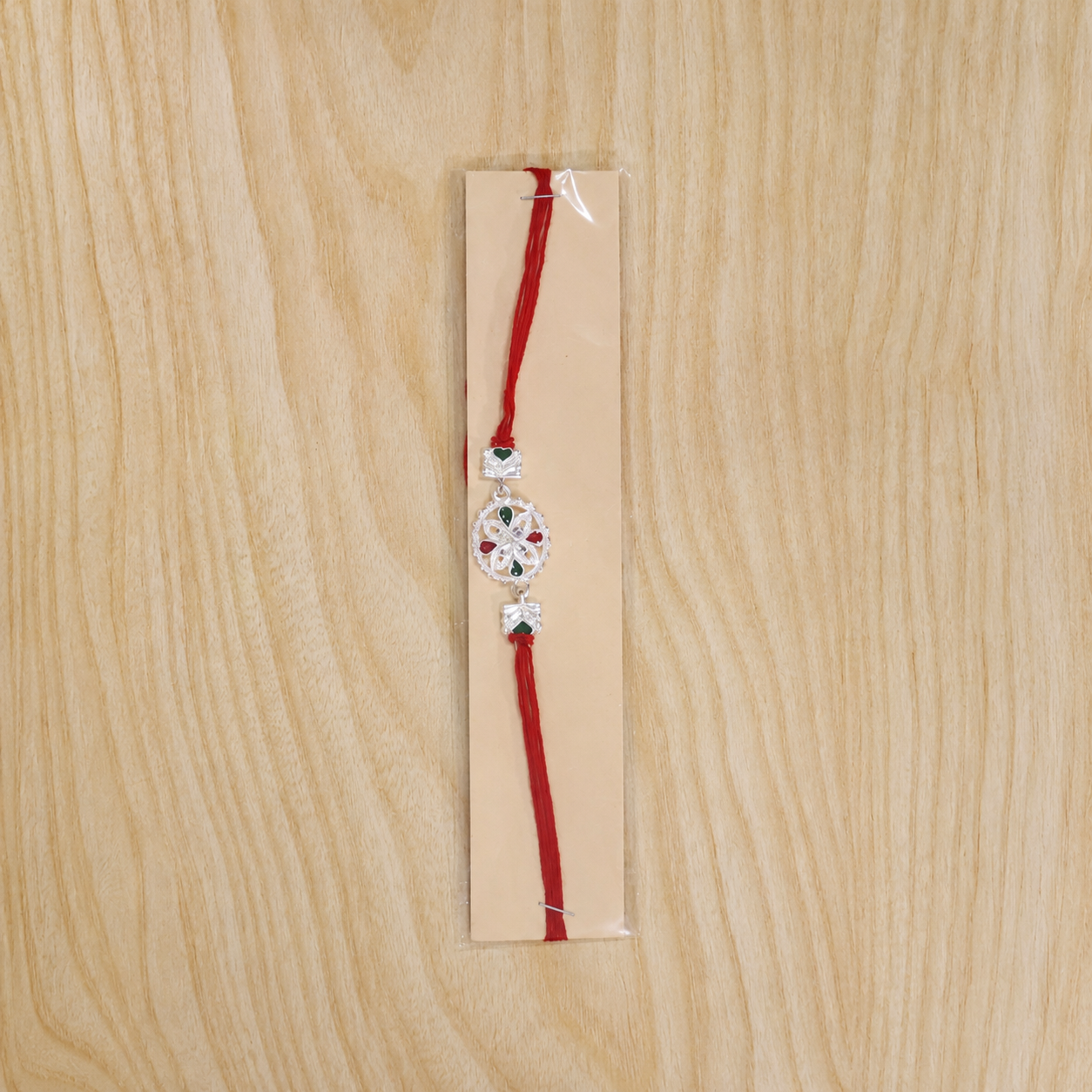 White Silver Floral Rakhi with Red Stone Center and Side Charms