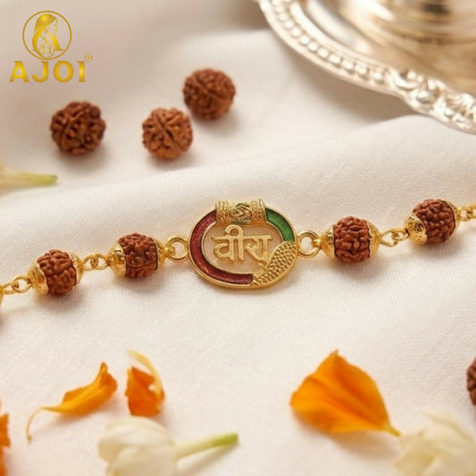 A gold bracelet with brown Rudraksha beads and a central oval charm with red and green enamel and Hindi script.