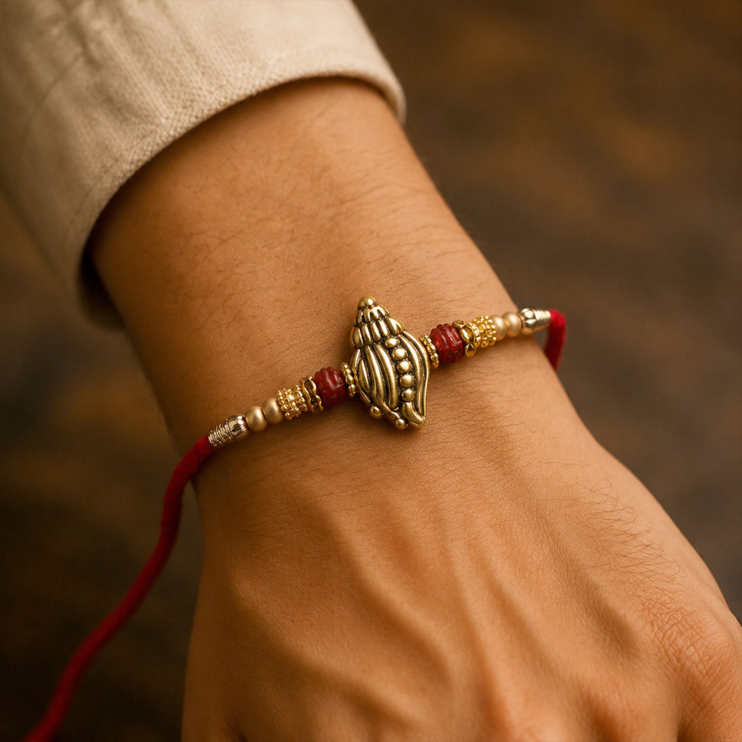 Shankh Conch Golden Devotional Rakhi with Pearl Beads, Red Accents and Antique Finish