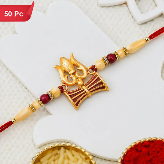A red thread with a gold trishul and damaru charm, flanked by red and cream beads with gold accents, rests on a white