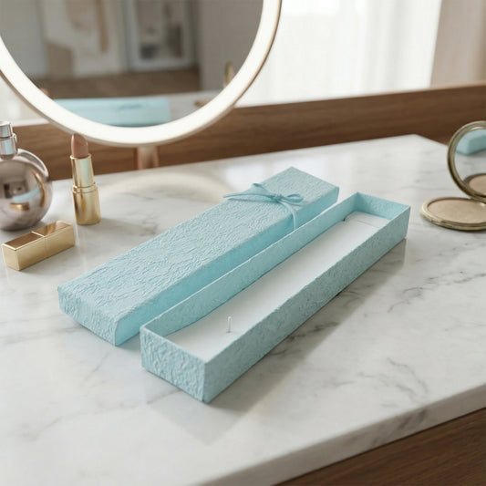 Long rectangular jewelry box with decorative ribbon closure