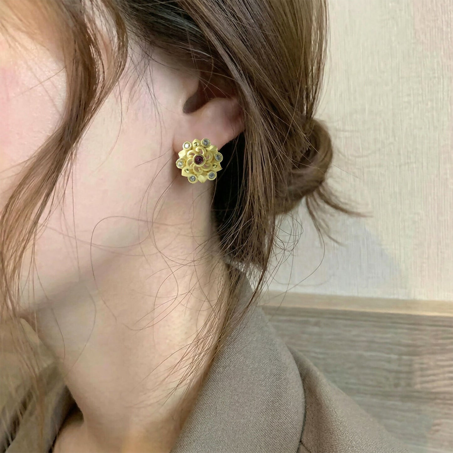 Gold stud earrings showcasing intricate floral pattern with multi-stones