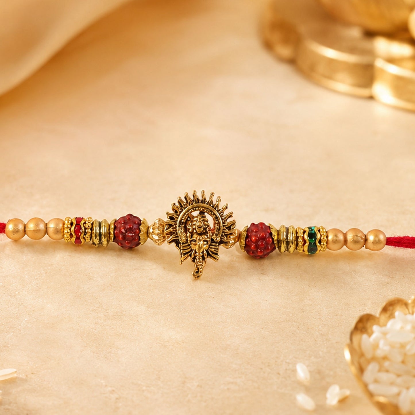 Ganesh Ji Antique Golden Devotional Rakhi with Red Beads and Pearl-Style Accents