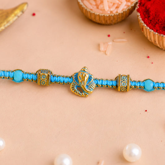 Turquoise designer rakhi with gold tone centre and elegant bead spacing.