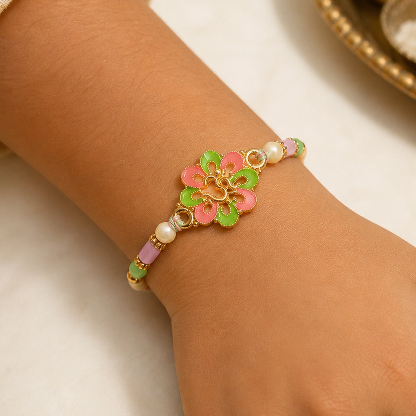 Om Flower Pendant Rakhi with Coral and Green Enamel