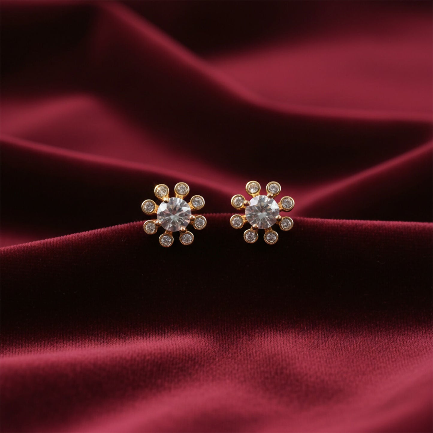 Flower design stone stud earrings on white background showing elegant gold finish