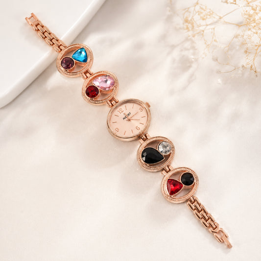 Women's rose gold analog bracelet watch with colorful crystal stones on a white background.