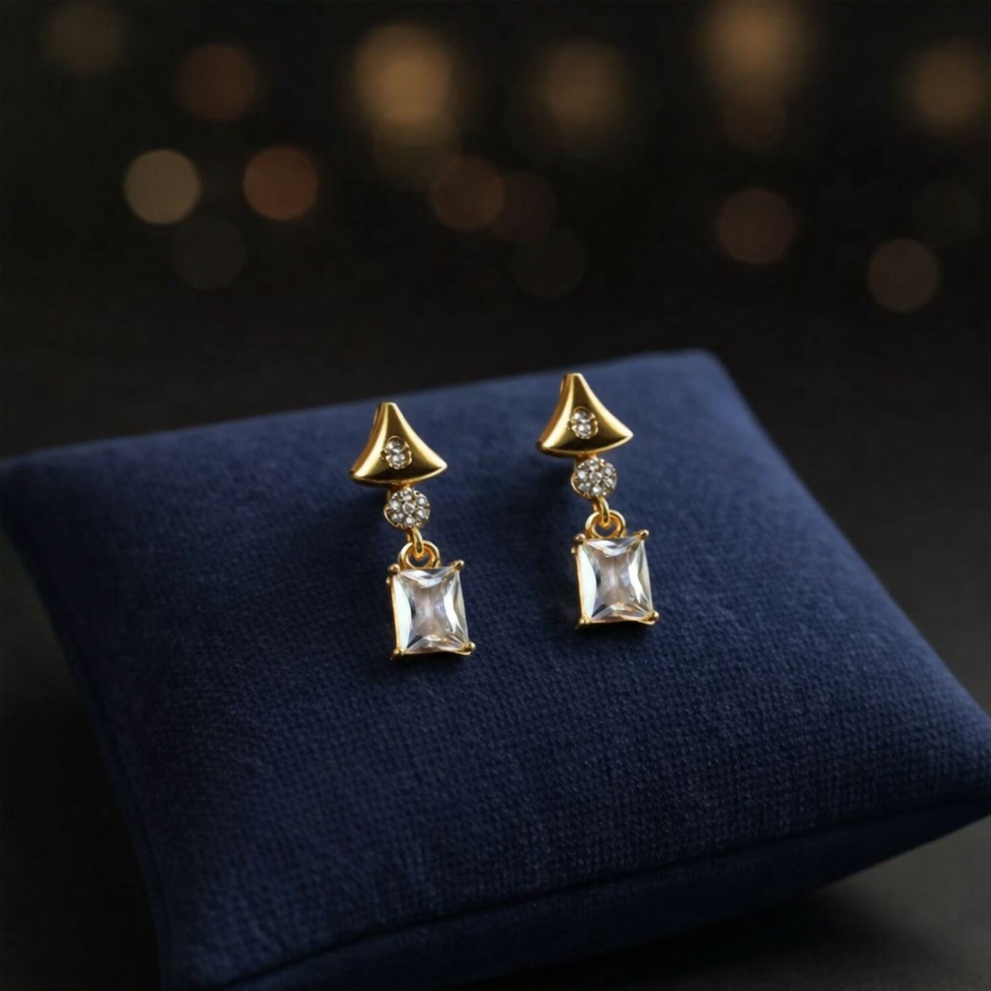 Gold tone crystal earrings displayed on a white background showing geometric design