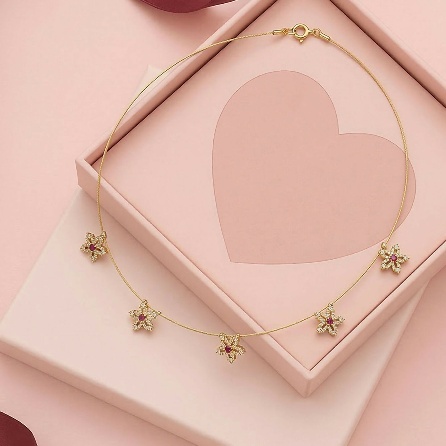 Gold chain necklace highlighting red centered floral star stones