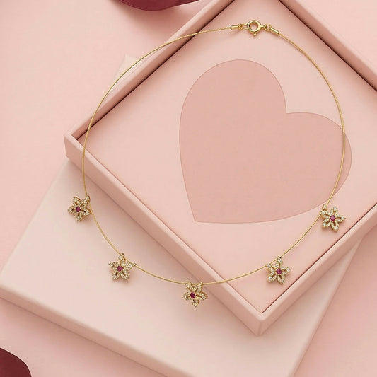 Gold chain necklace highlighting red-centered floral star design