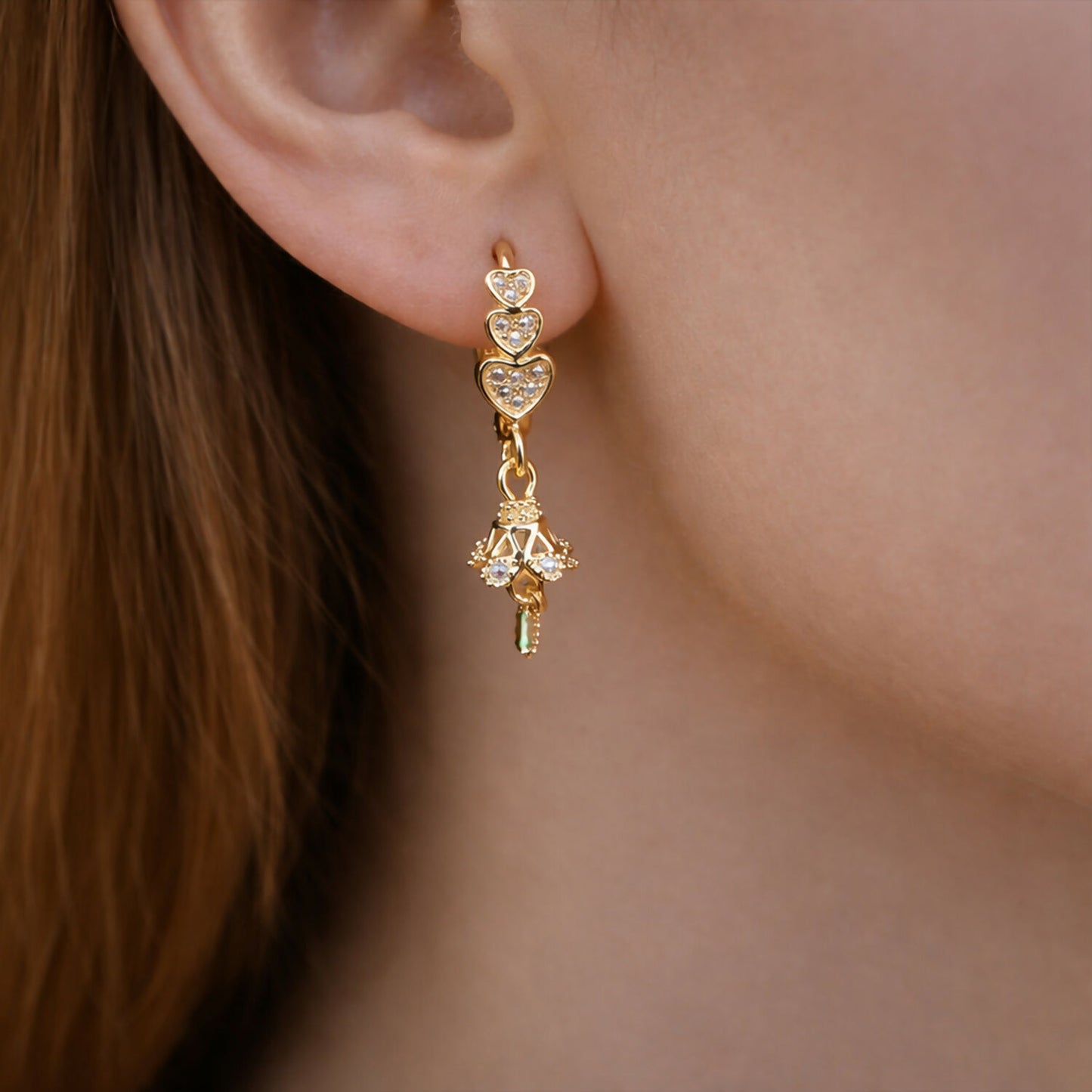 Close-up of elegant triple heart layered earrings featuring sparkling stones