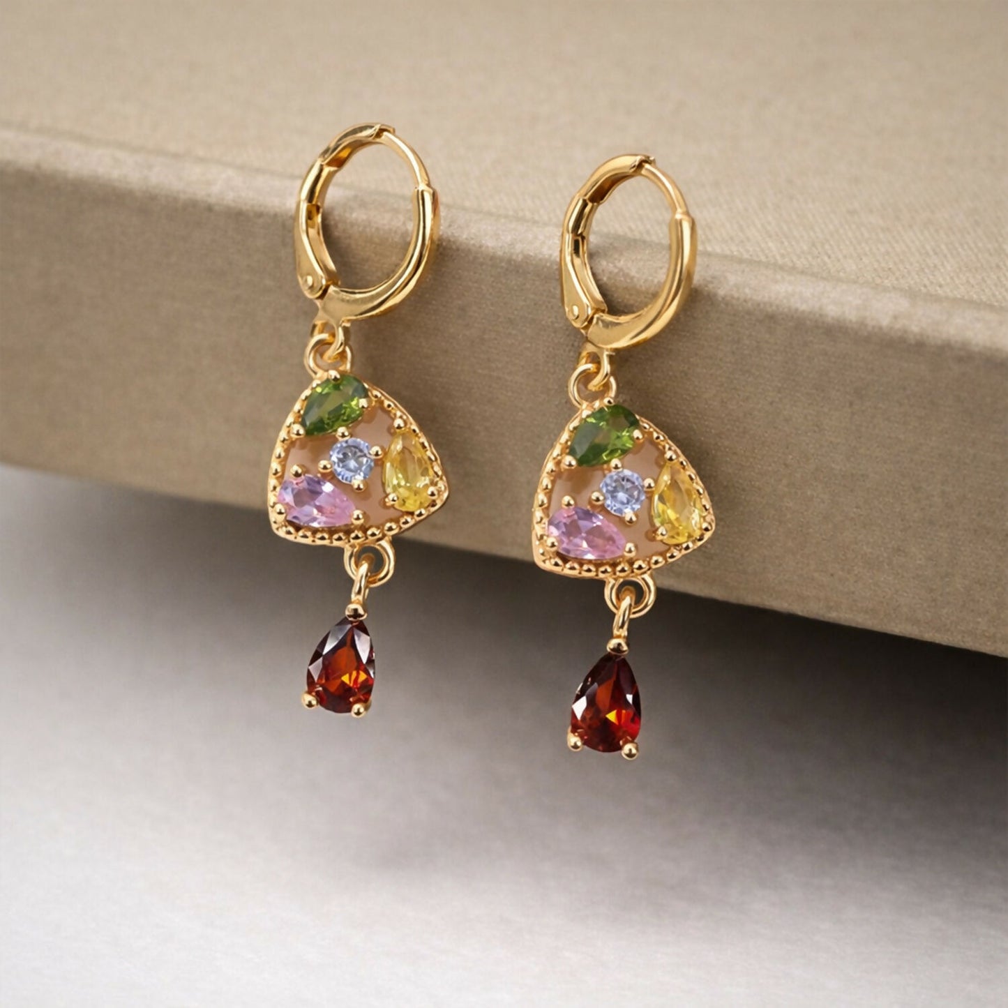 Side view of gold-tone multicolor stone drop earrings with sparkling triangular charm