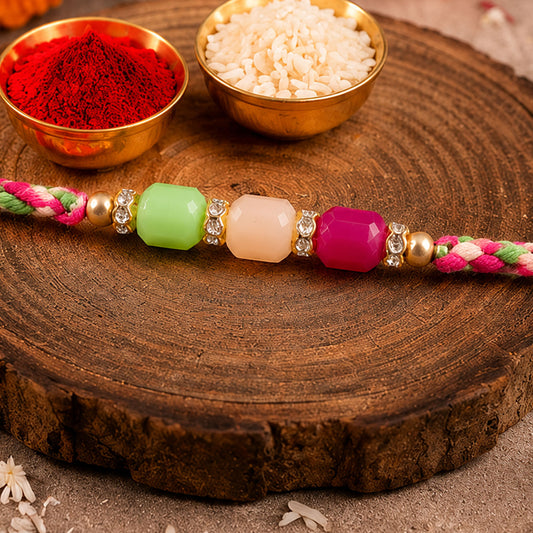 Close-up of bright macrame bracelet Rakhi with green peach pink beads on a white background.