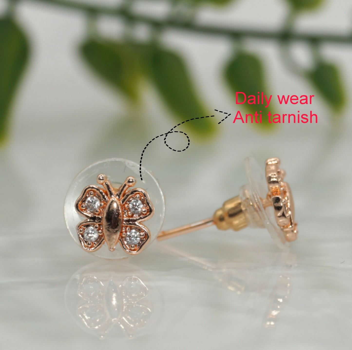 Close-up of rose gold plated butterfly stud earrings showing intricate cubic zirconia sparkle