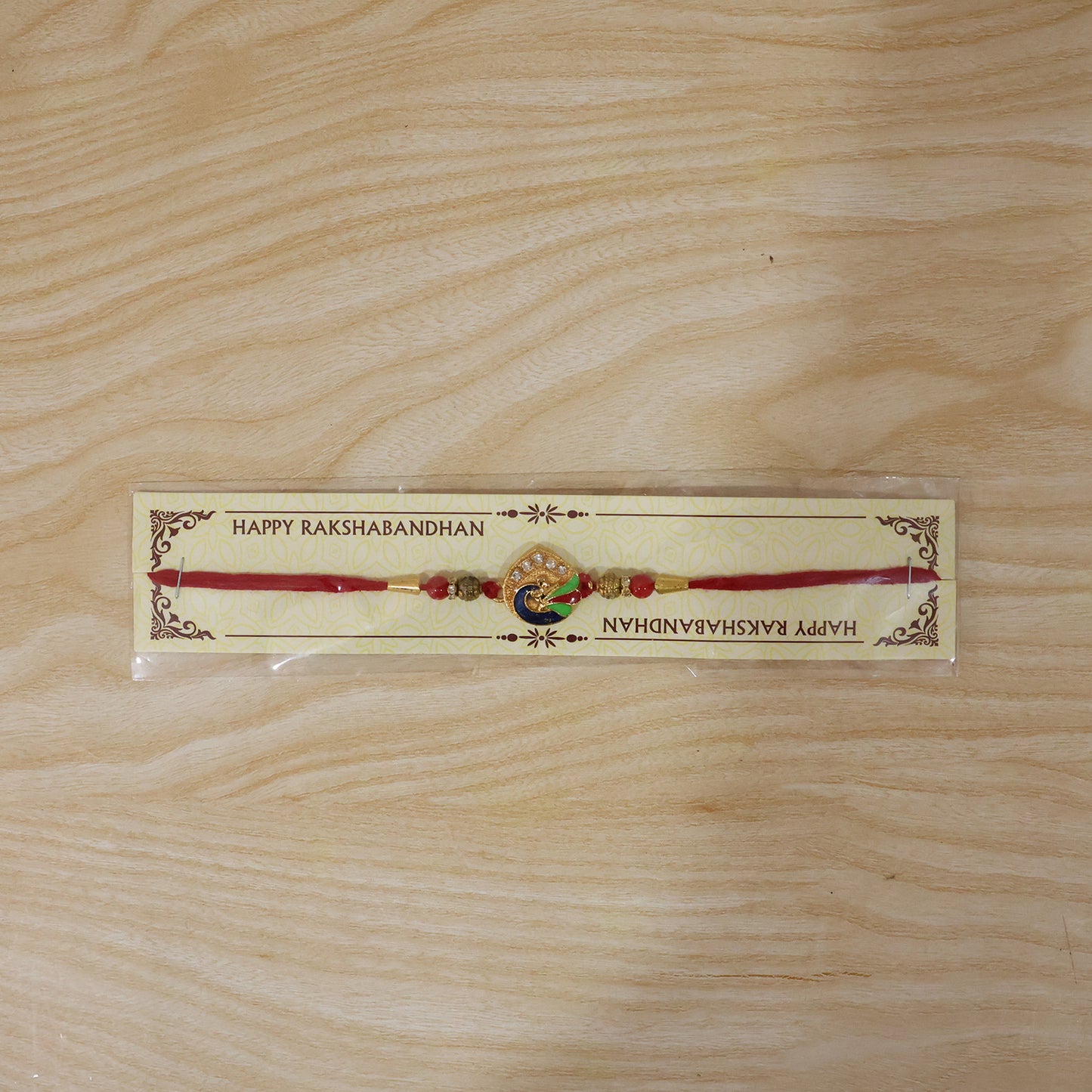 Peacock Feather Rakhi with Red Beads and Cute Mor Charm