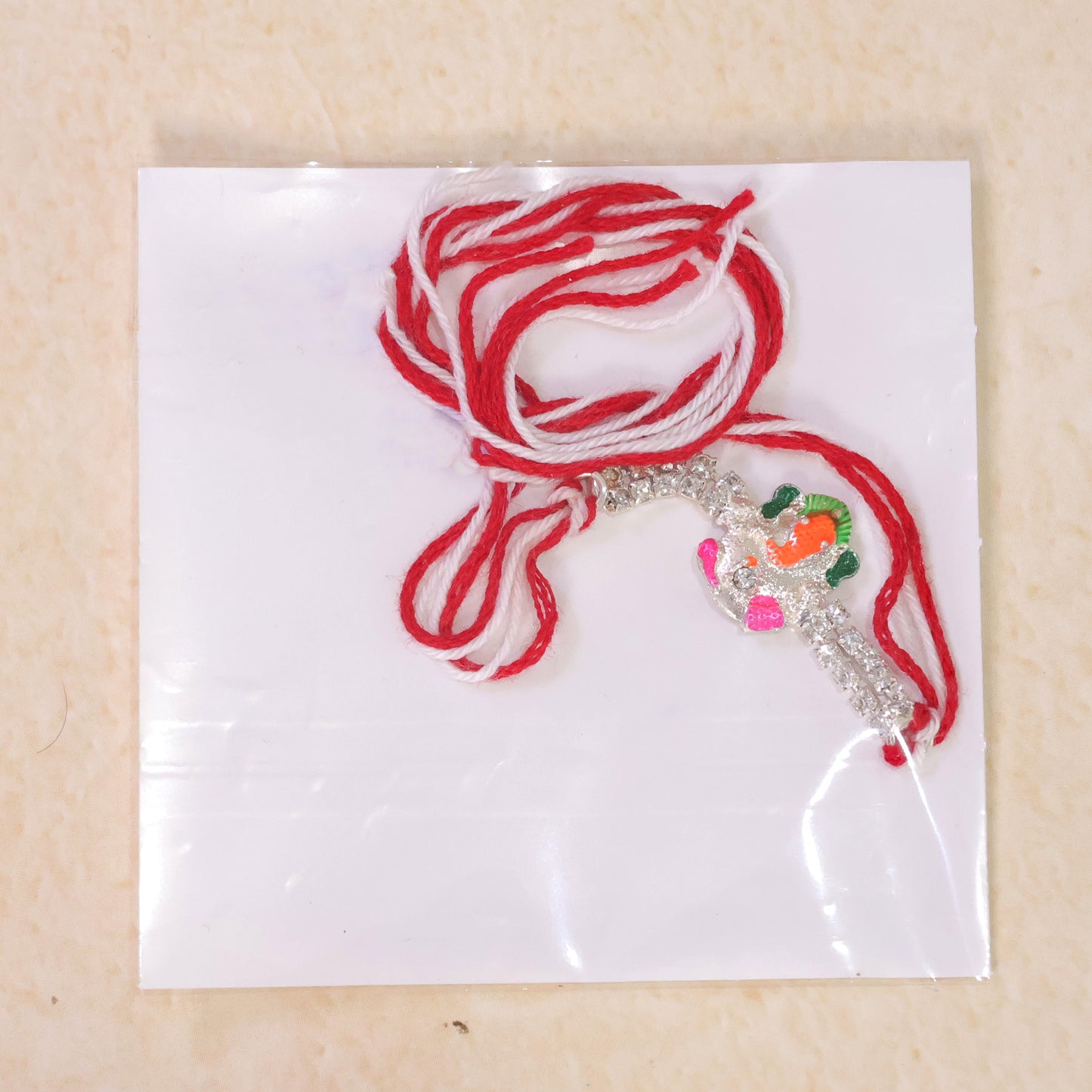 Elegant Rakhi featuring Ganesha Charm, crystal accents and thread style for Gift Use