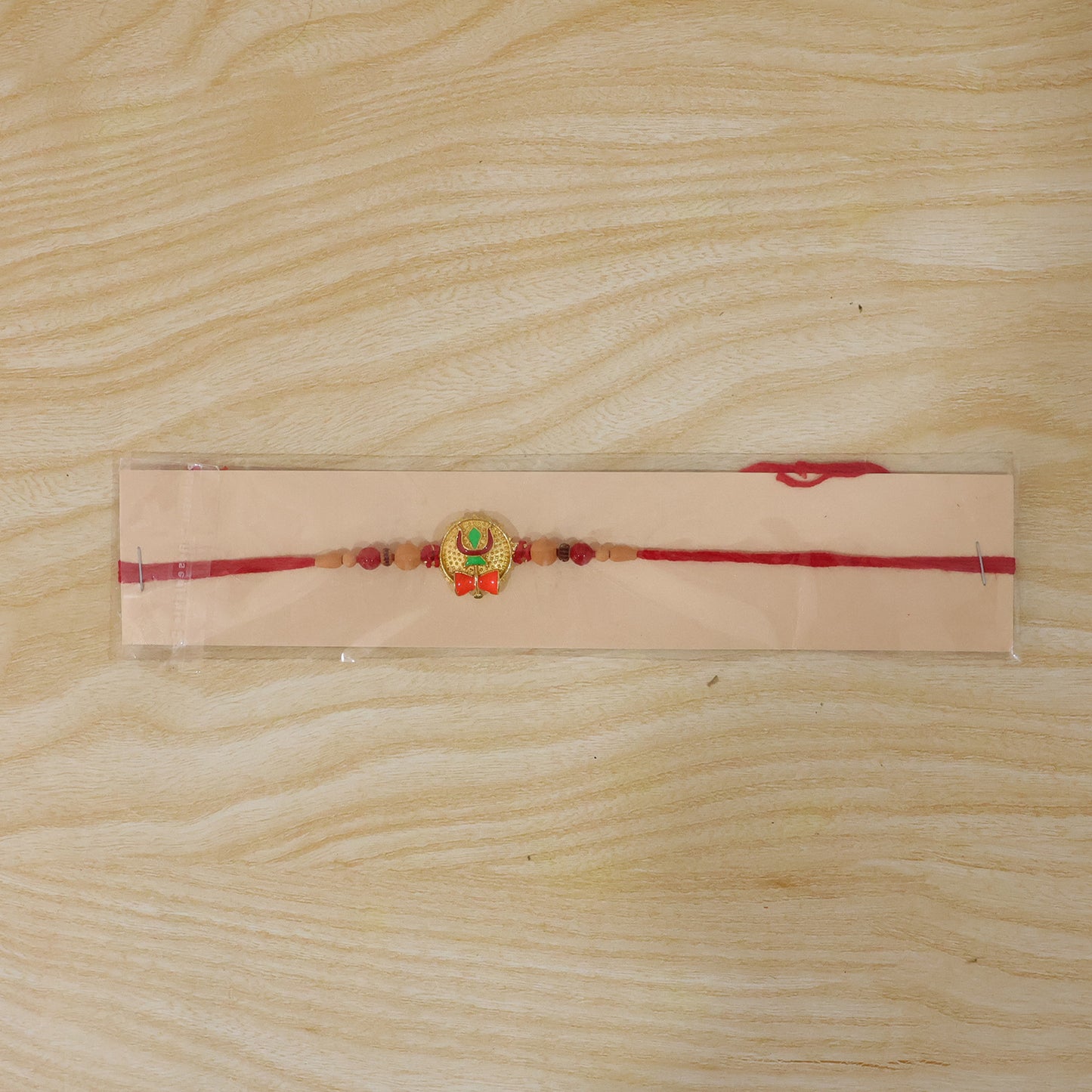 Trishul Damru Rakhi with Peach Beads and Red Thread