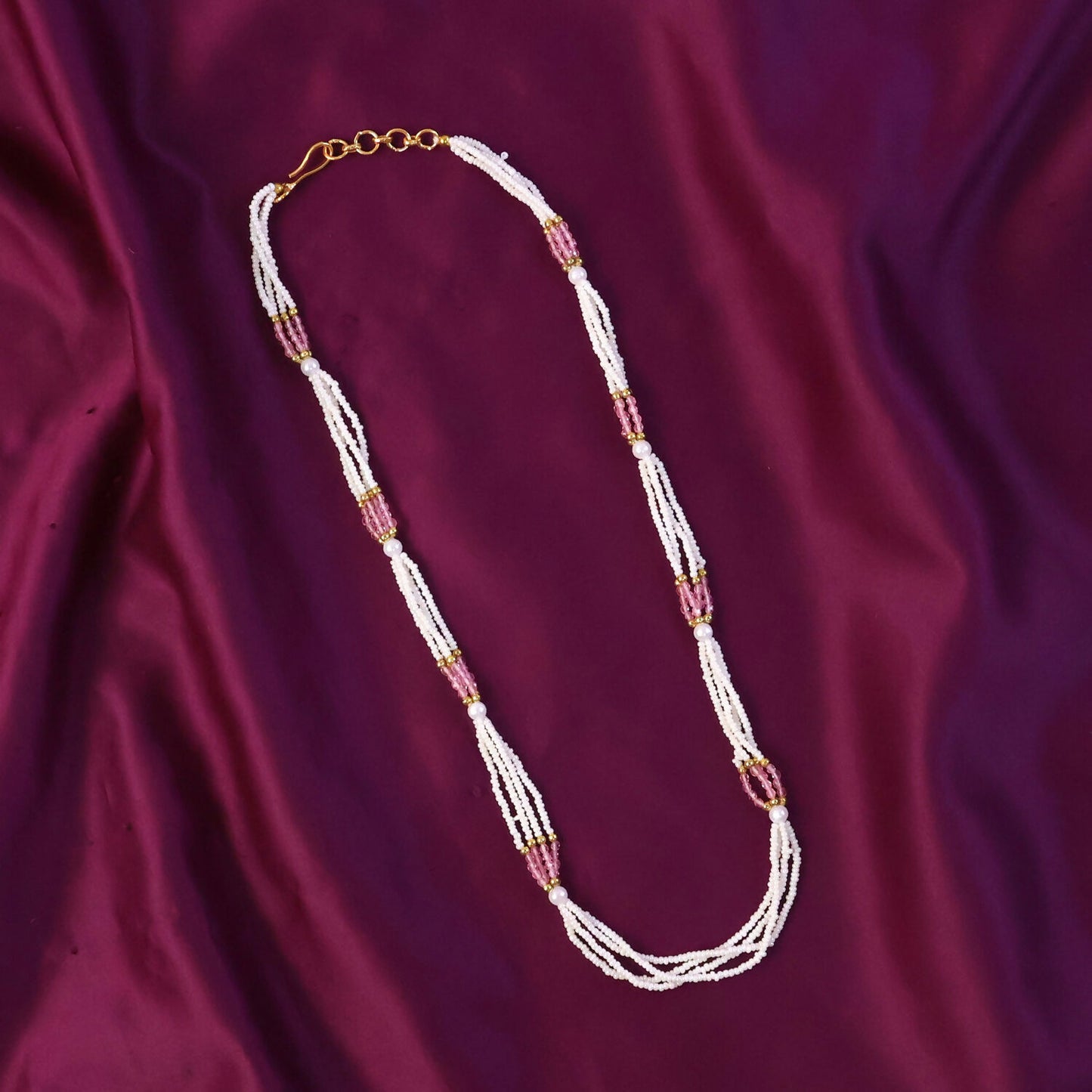Close-up of pearl-like beads and pink accents on mala necklace, feminine jewelry