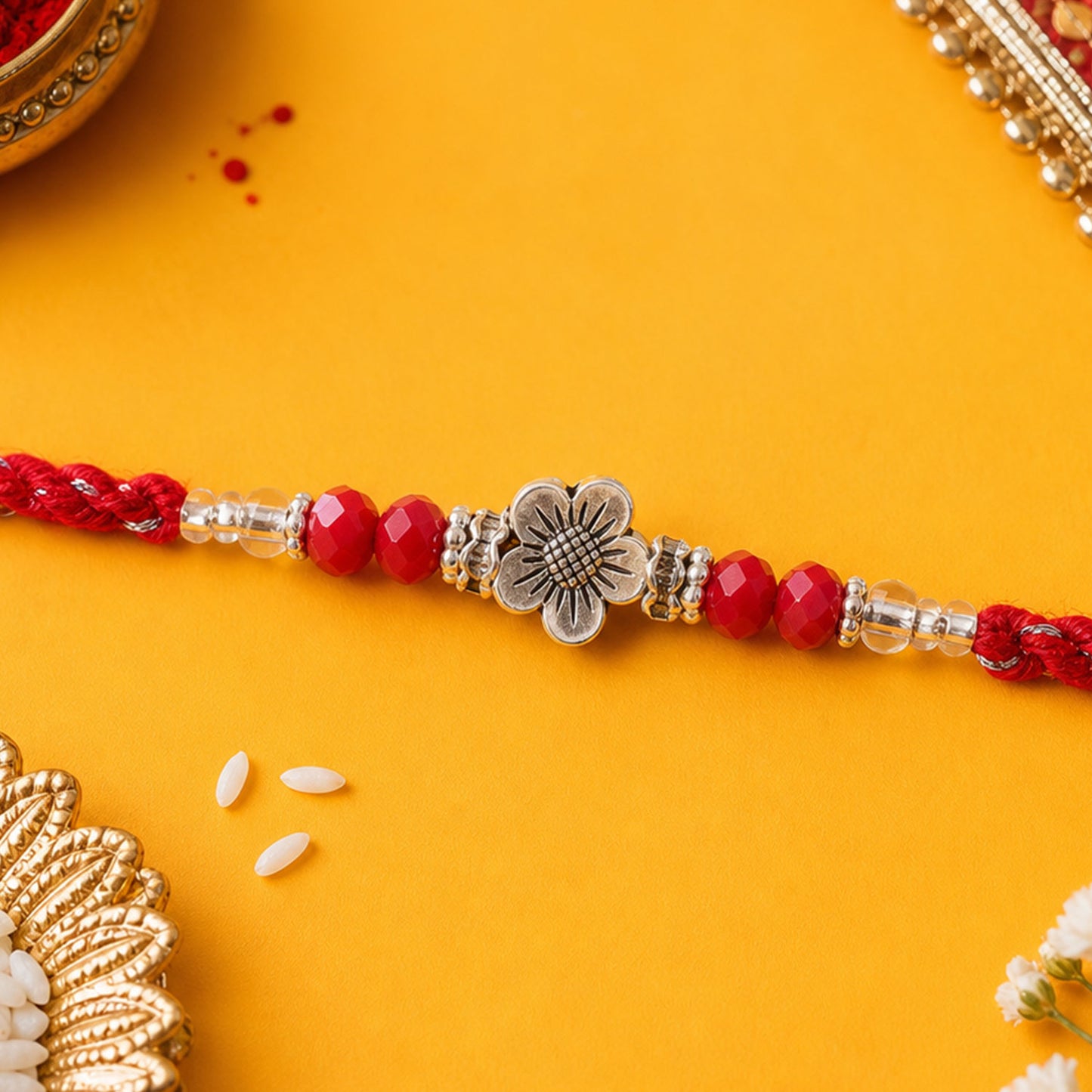 Red Braided Rakhi with Silver Flower Charm and Crystal Bead Accents