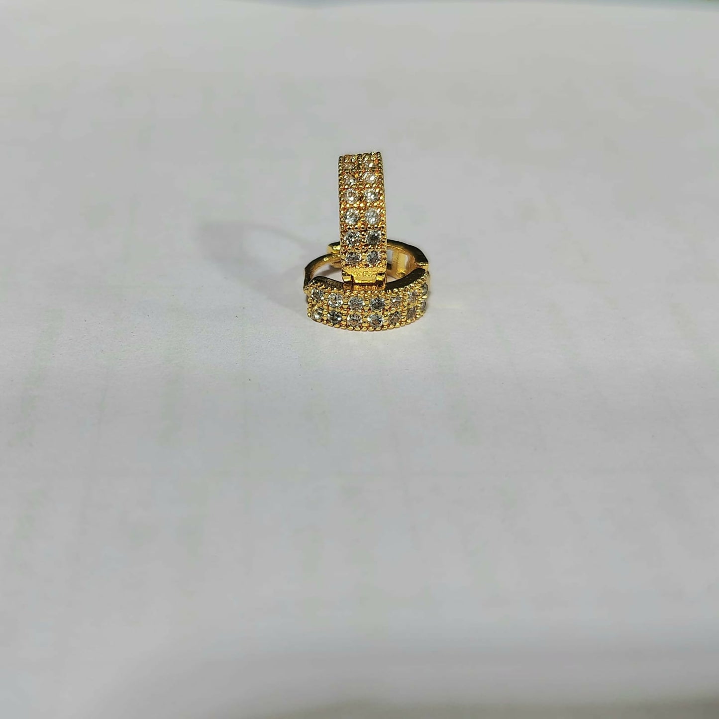Single gold plated huggie hoop earring featuring multicolored CZ stones