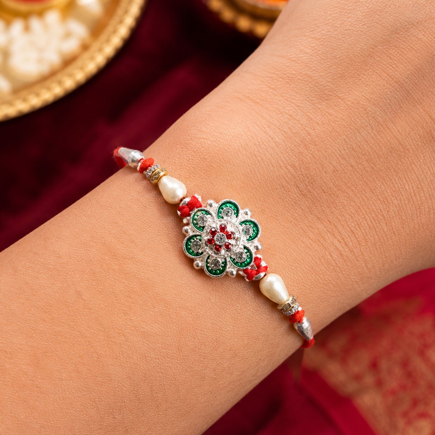 Green Flower Rakhi with Red Beads and Pearl Thread Styling