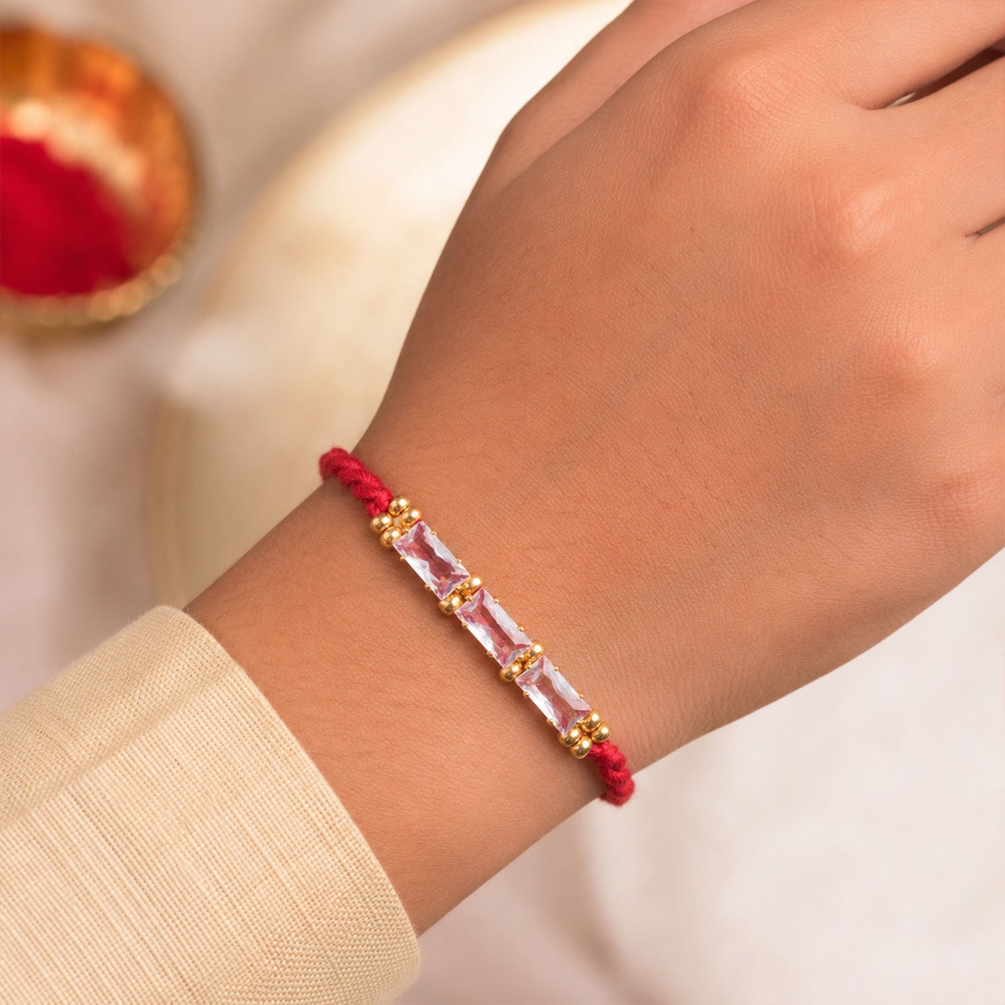 Red Thread Rakhi with a Row of Pink Baguette-Cut Crystal Beads