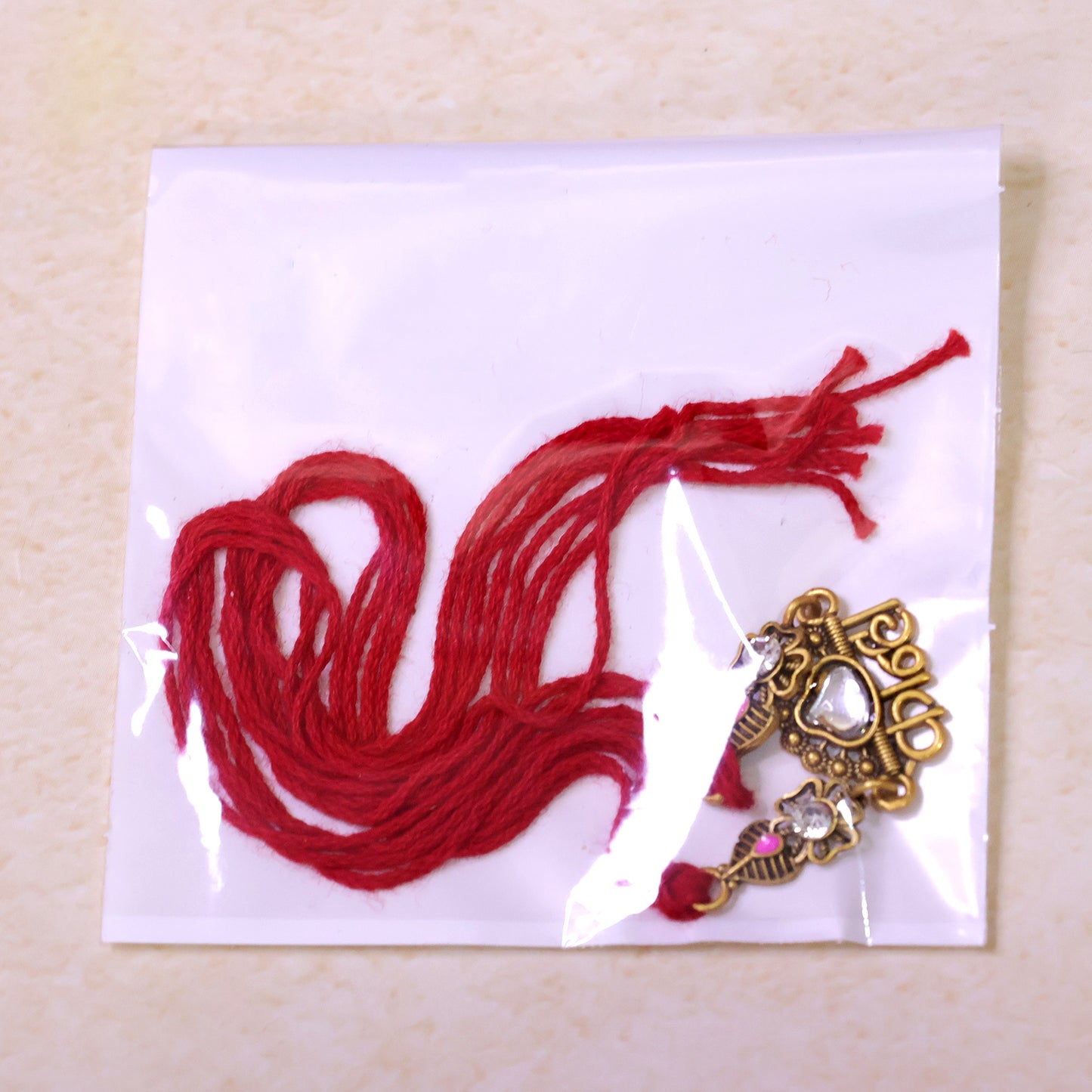 Antique Gold-Toned Kanha Rakhi with Kundan-Style Stone, Crystal Accents & Red Thread