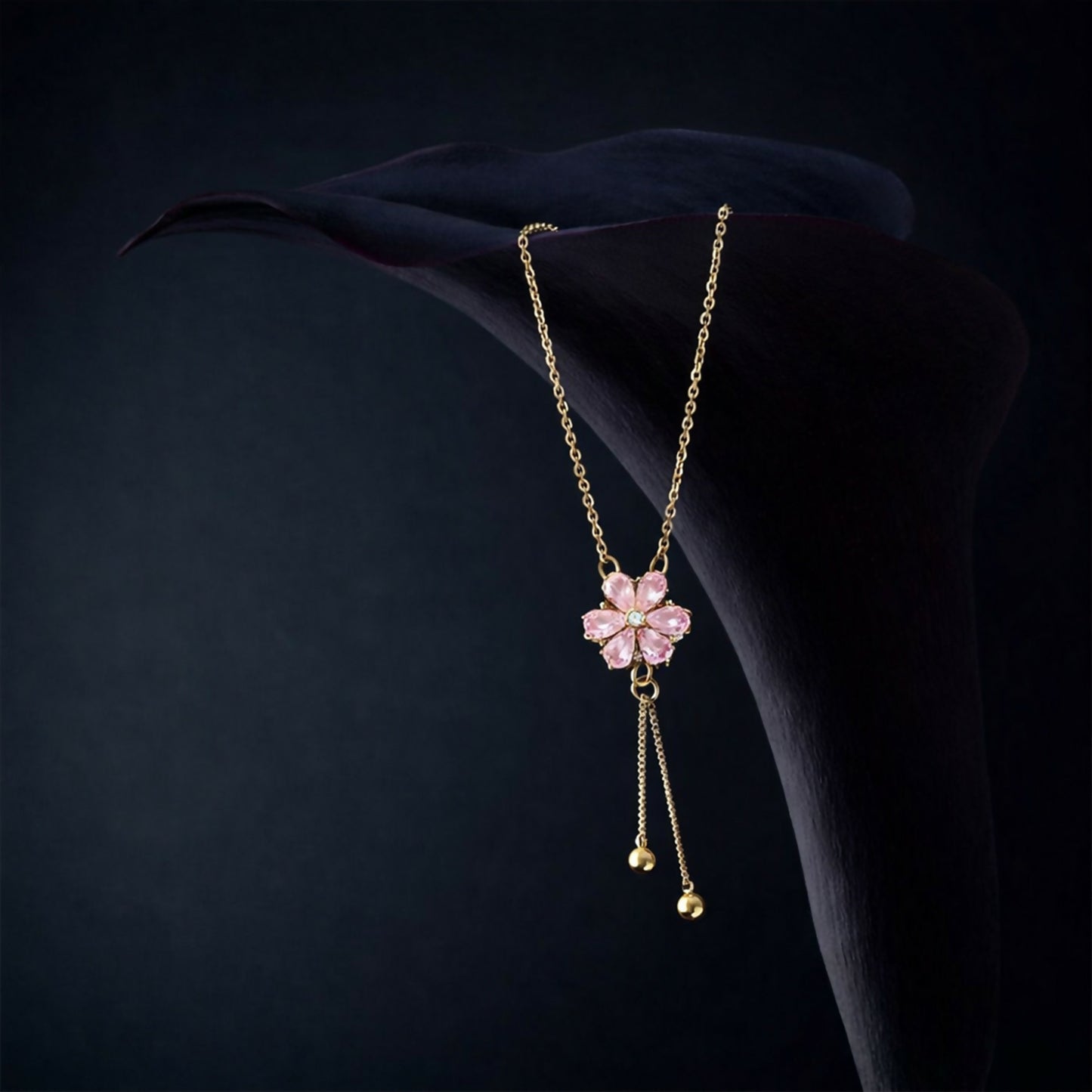 Stylish twin drop tassels with polished bead accents hanging from a pink crystal pendant necklace