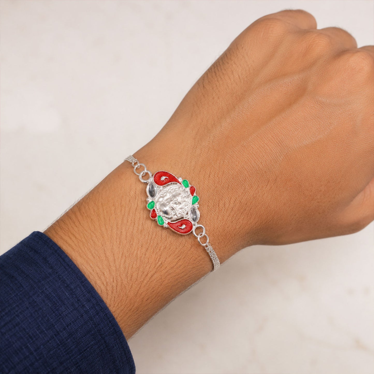 A brother's wrist adorned with the beautifully designed Ganesha Rakhi, celebrating sibling love.