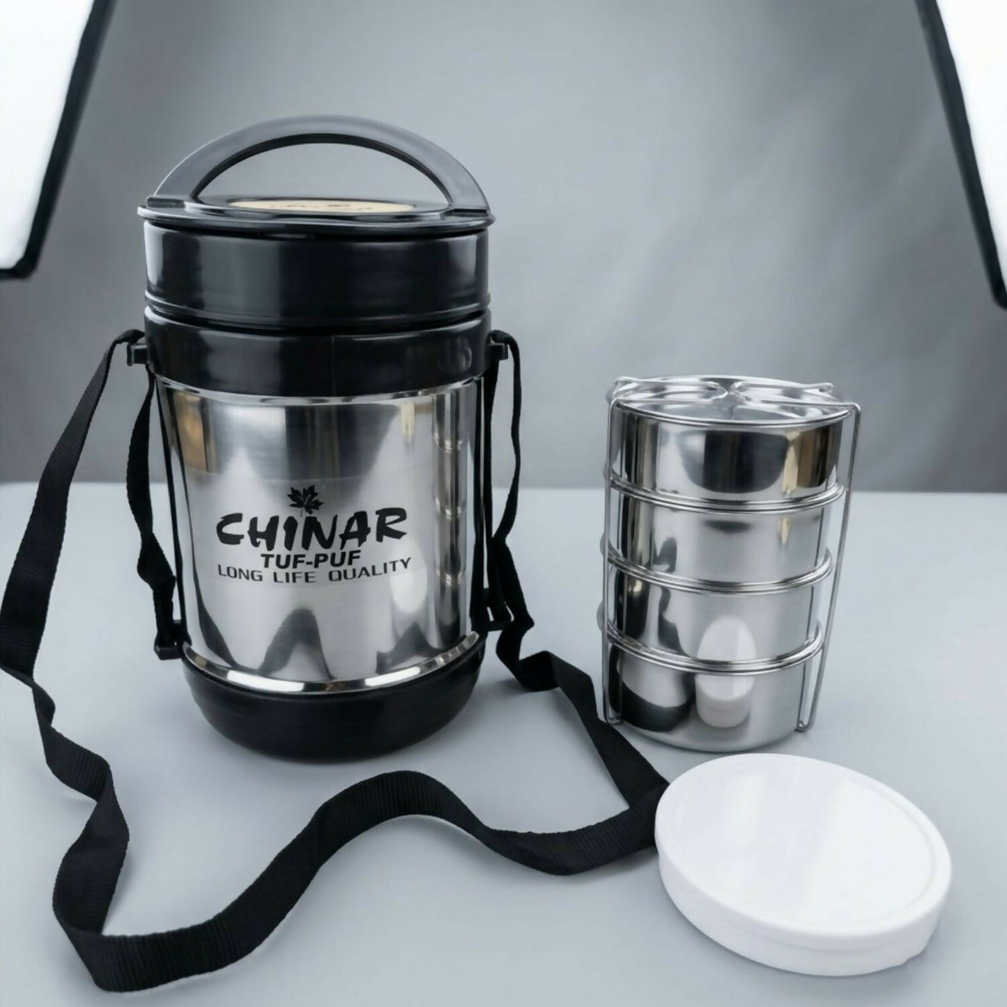 Modern silver stainless steel lunch box with black accents, portable design