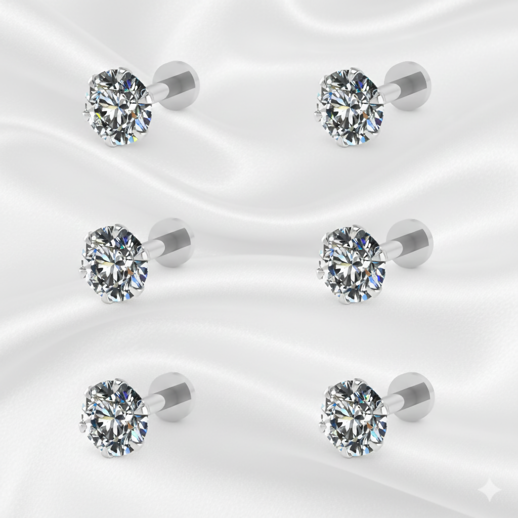 Multiple pairs of silver plated round CZ stud earrings arranged on white background