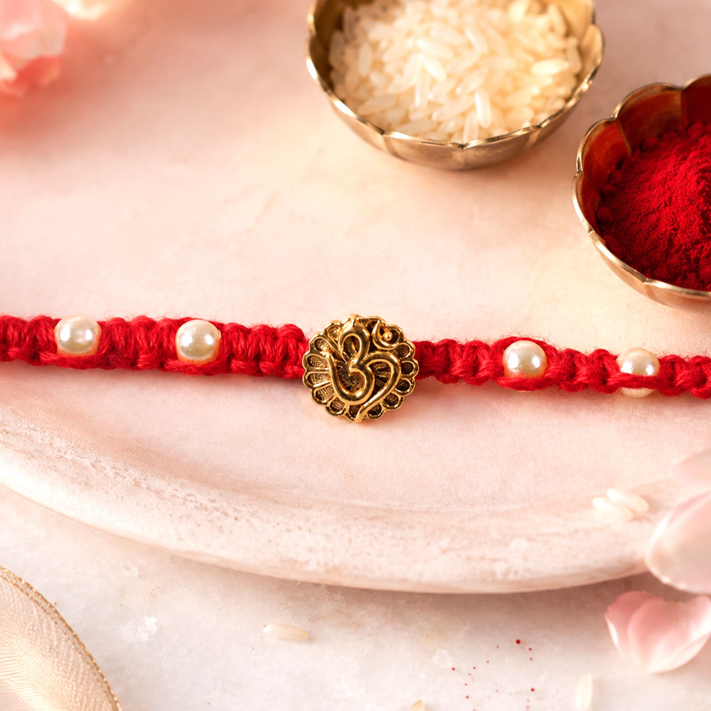 Red Braided Rakhi with Antique Gold Om Pendant and Lustrous Pearls