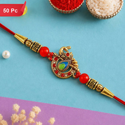 A red thread bracelet with a golden peacock centerpiece adorned with red, green, and blue stones, flanked by red beads and