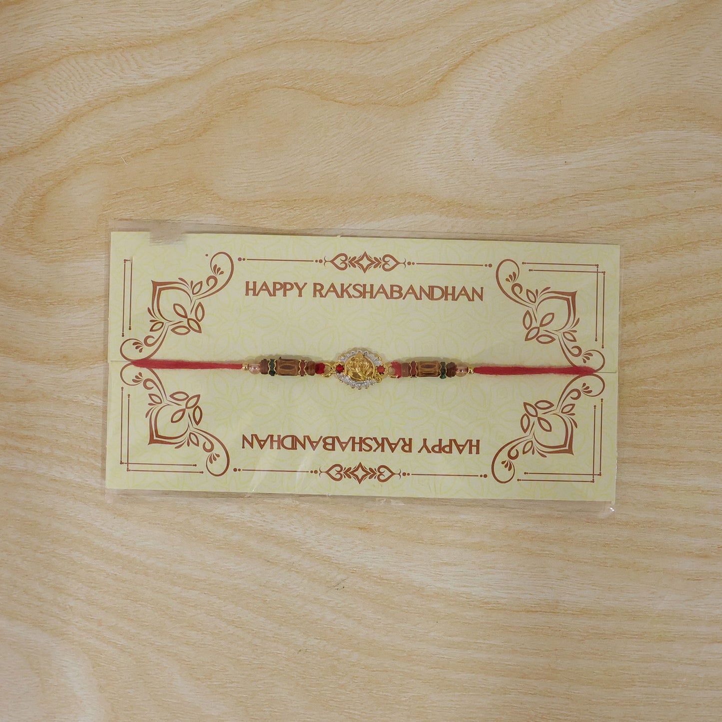 Ganesha Silver Ring Devotional Rakhi with Circular Centre and Red Green Beads