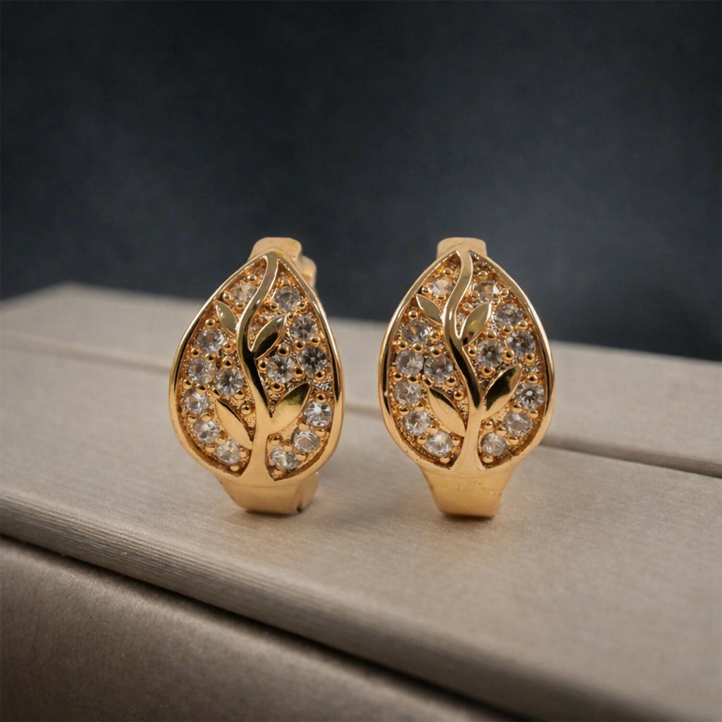 Leaf design stud earrings worn to highlight delicate gold-tone shine