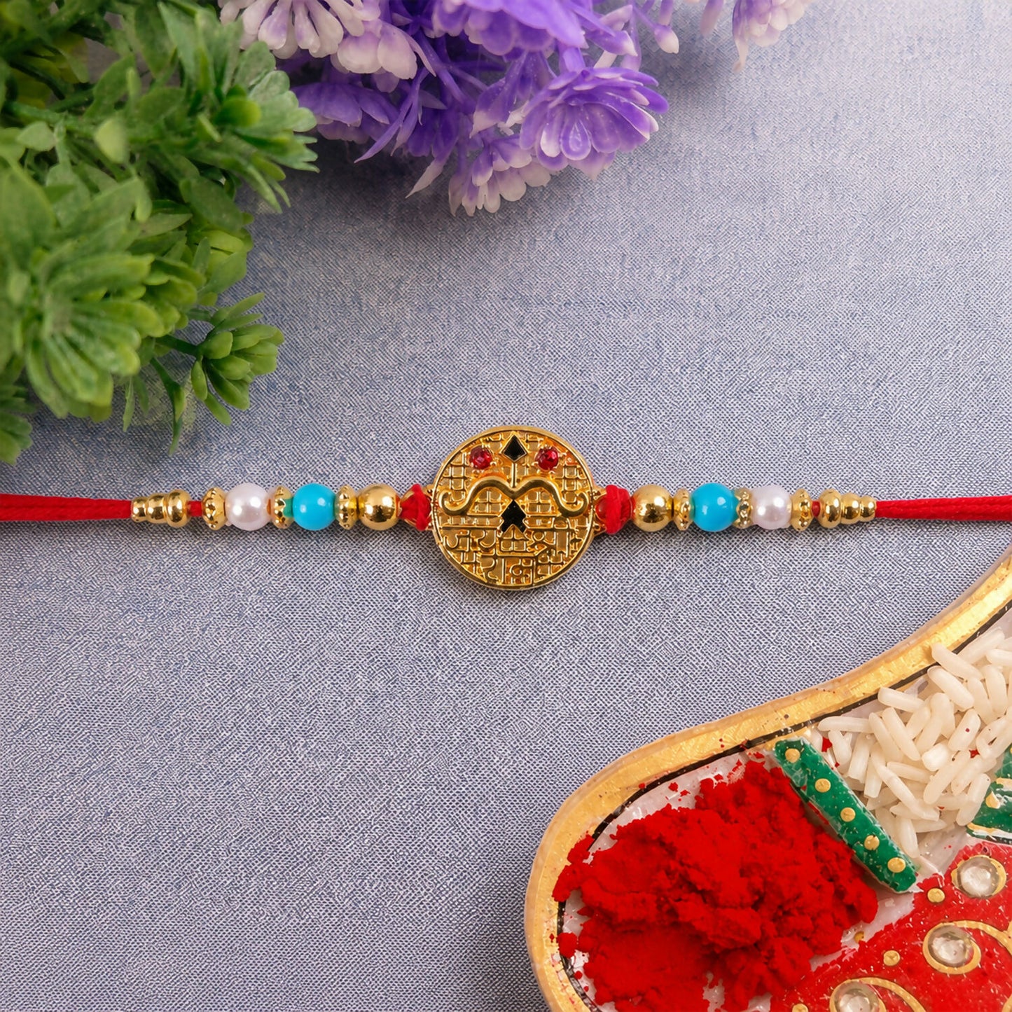 Side view of Golden Shri Ram Rakhi with blue beads