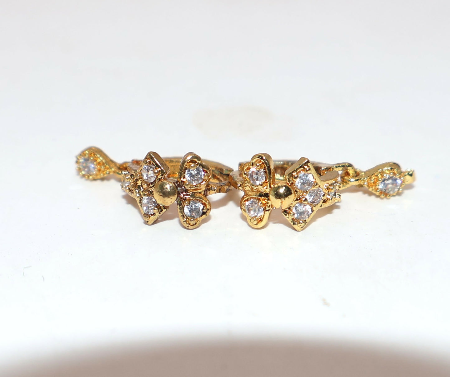 Gold plated swan motif huggie hoop earring with dangling cubic zirconia stone detail