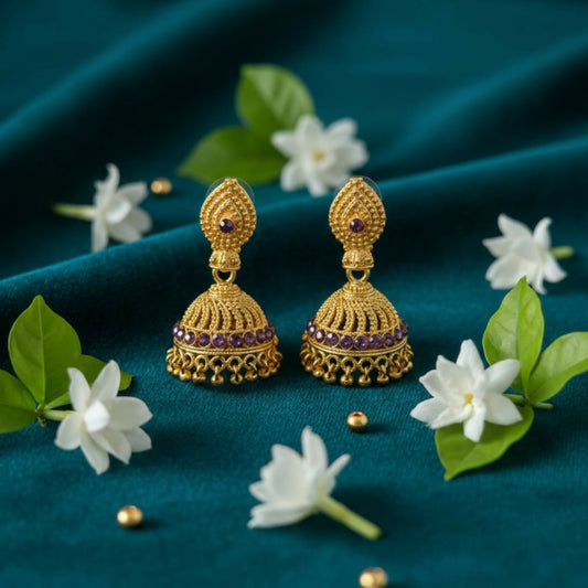 Golden jhumka earrings with intricate filigree and enamel accents on circular studs