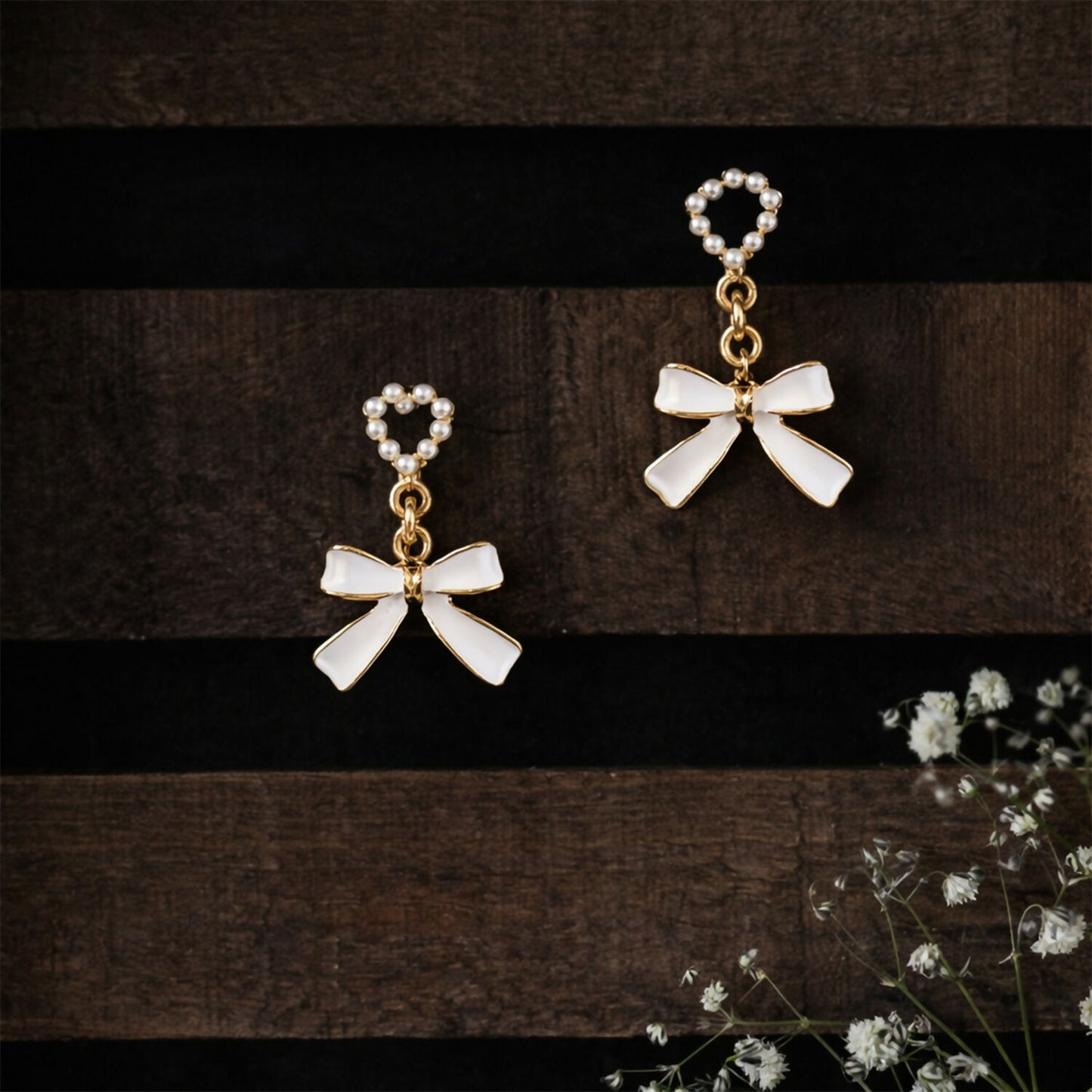 Pearl heart and bow earrings displayed with subtle shadows