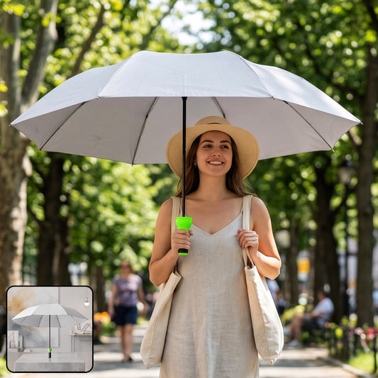 Woman holding a large grey umbrella with a bright green handle while walking in a park.