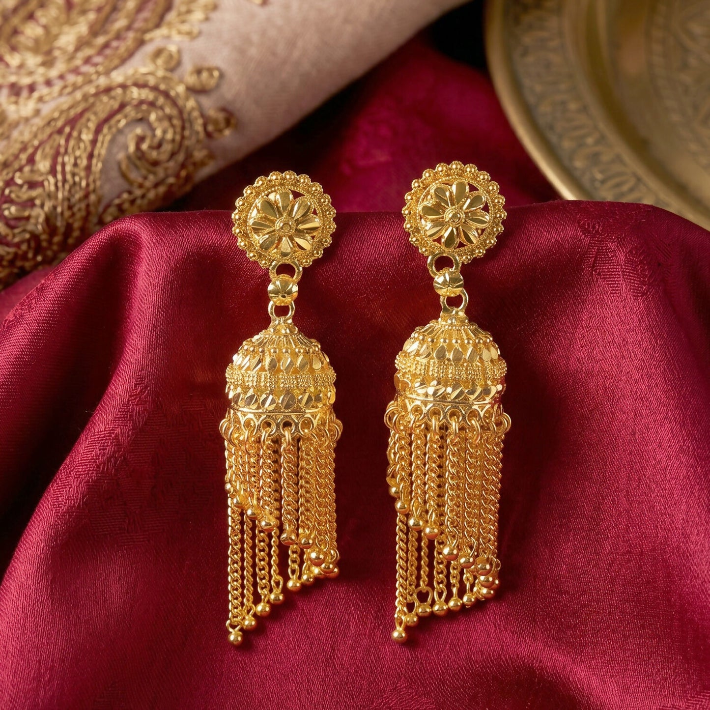 Front view of golden jhumka earrings with beaded tassels