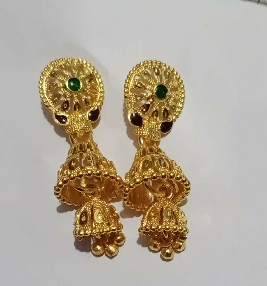 Elegant gold plated traditional jhumka earrings displayed with colorful ethnic outfit