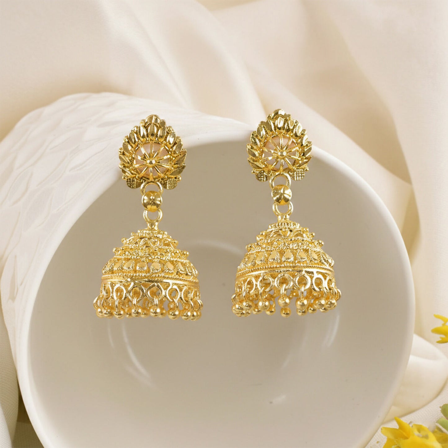 Close-up of gold dome jhumka earrings showcasing intricate floral craftsmanship