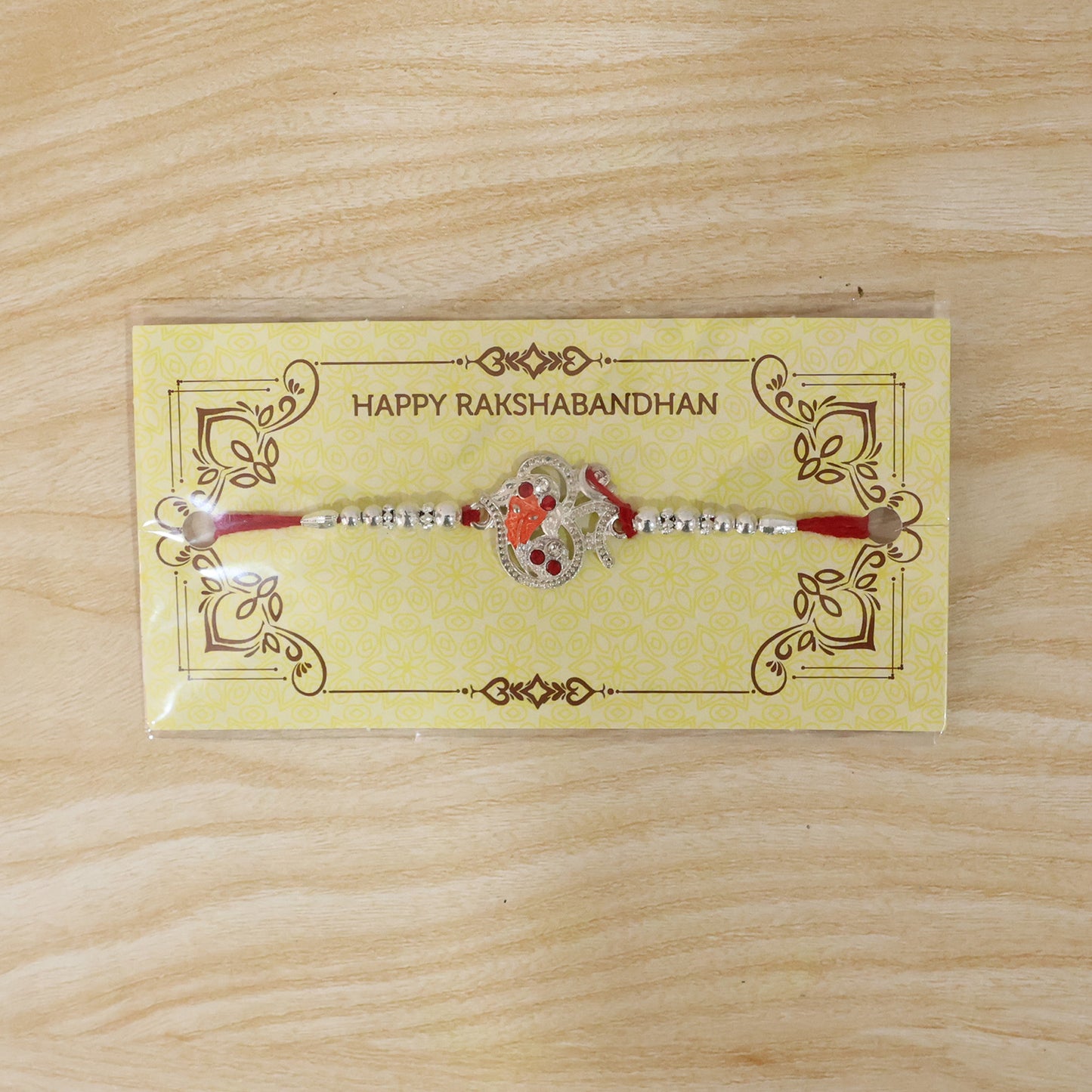 Silver Om Ganesh Rakhi with Red Stones and Metal Bead Chain