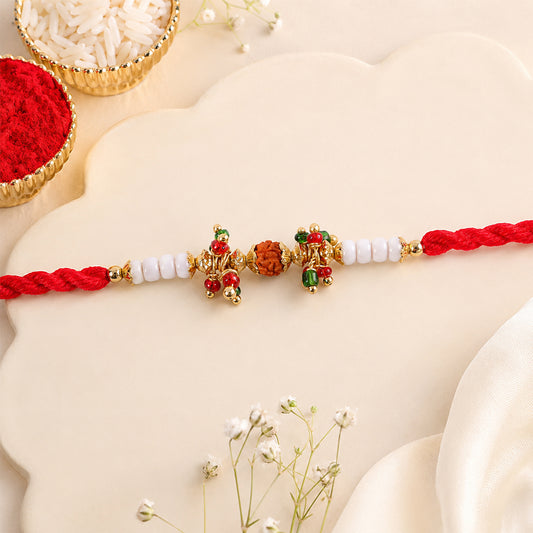 Red Pearl Designer Rakhi with golden accents and intricate details.