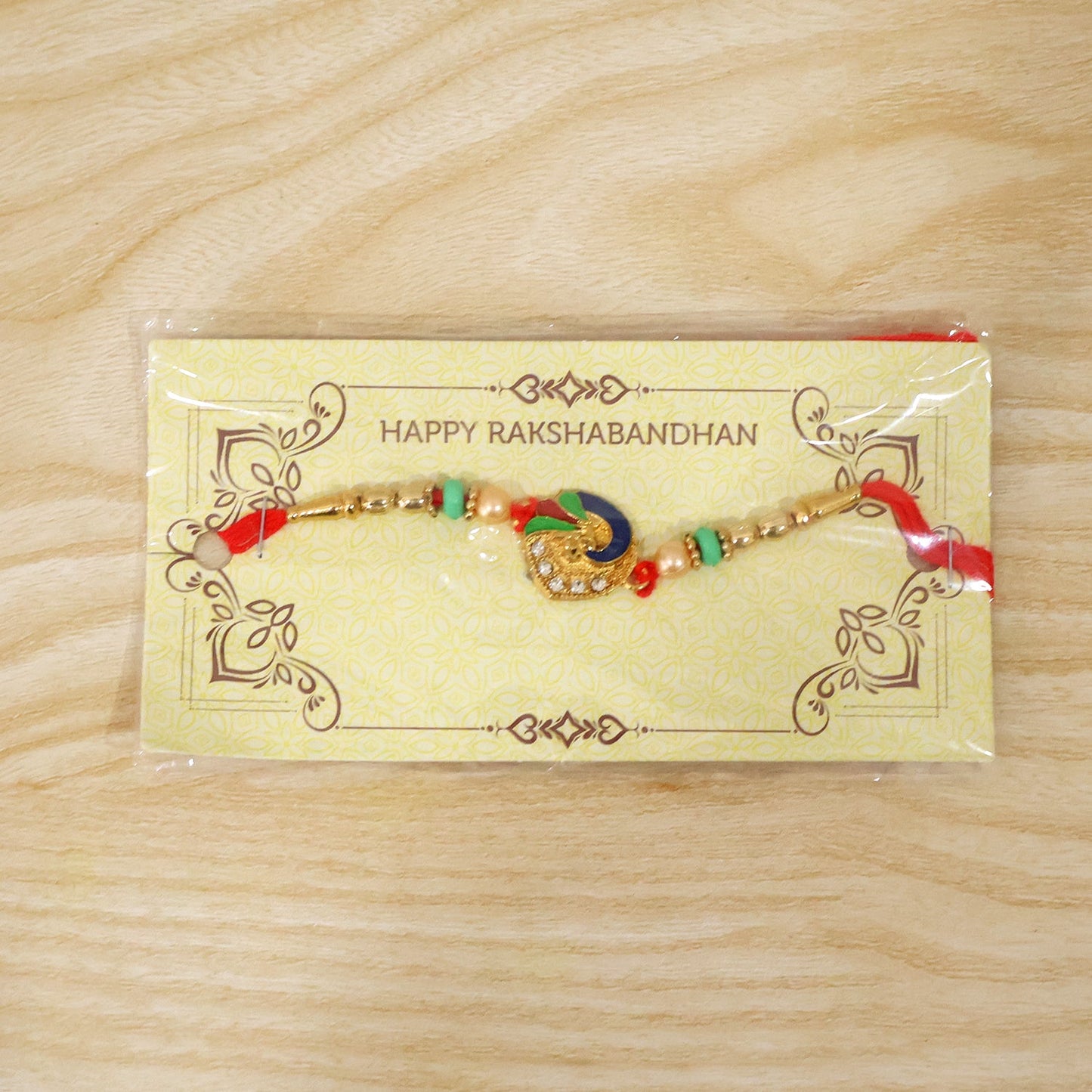 Peacock designer rakhi with pearl beads and red tying thread