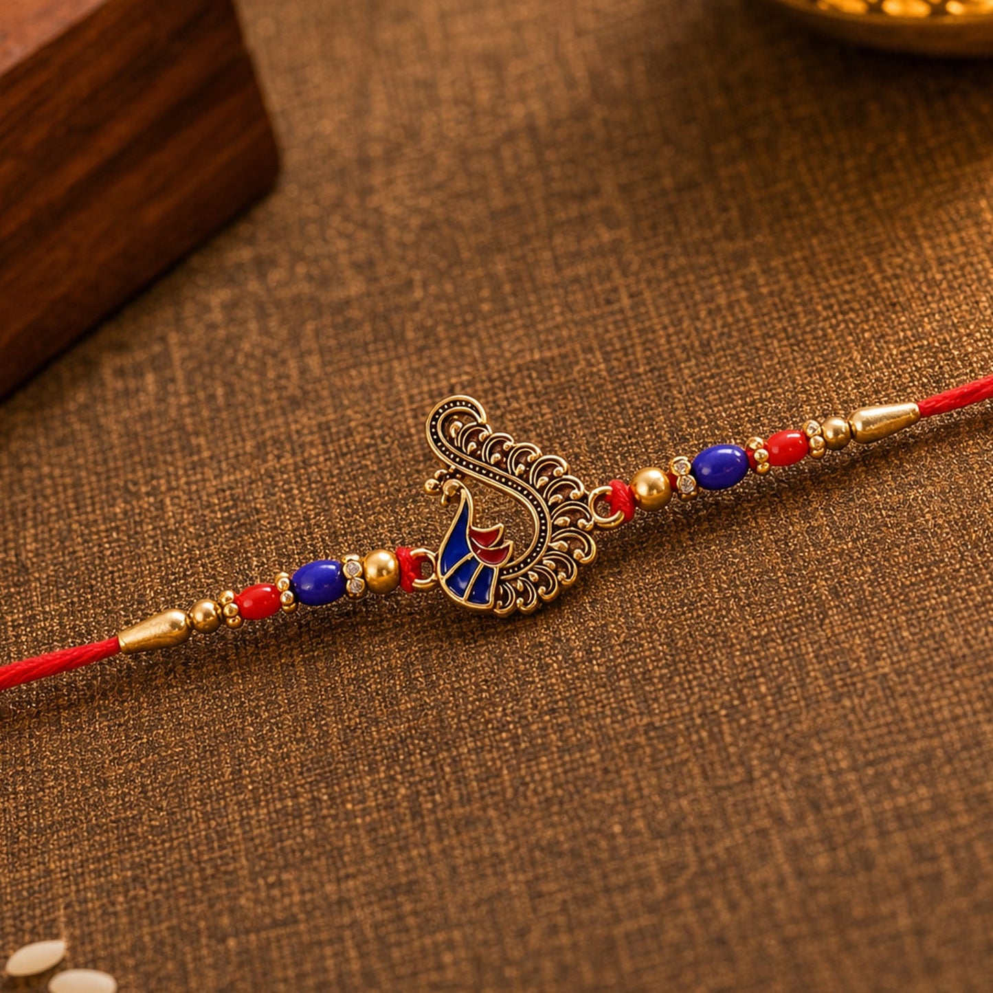 Festive rakhi with peacock charm and decorative beads