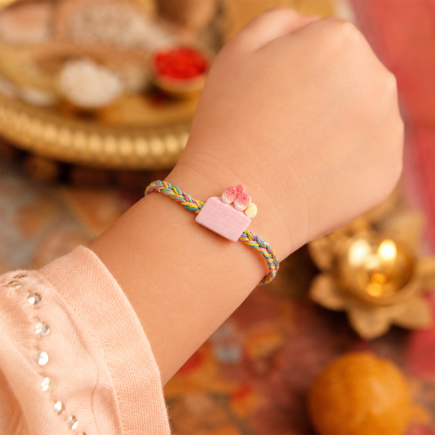 Rakhi tied with red thread and charm