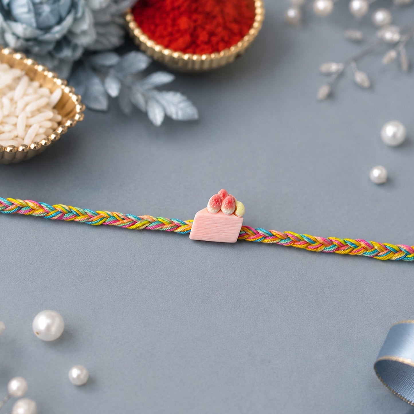Designer rakhi with strawberry cake charm detail