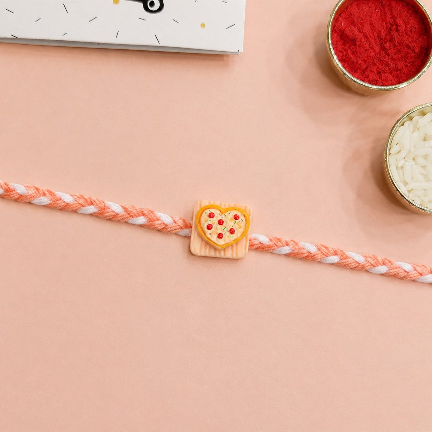 Heart pizza charm rakhi tied around wrist